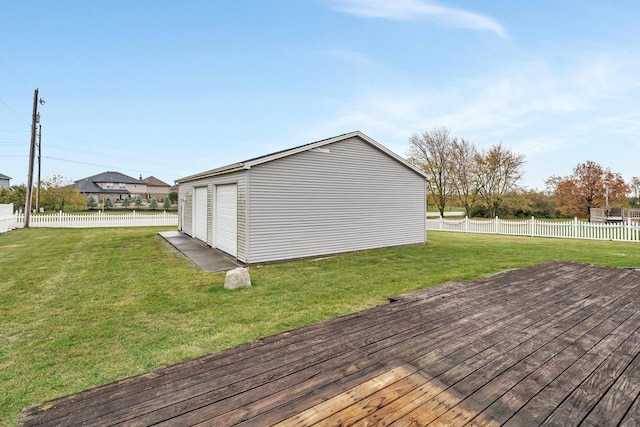 wooden deck featuring an outdoor structure, a garage, and a yard