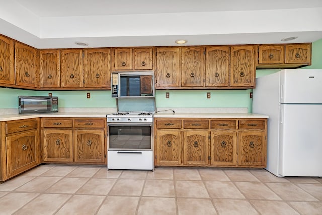 kitchen featuring light tile patterned floors and white appliances