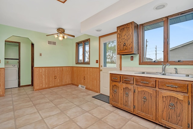 kitchen featuring washer / clothes dryer, ceiling fan, and sink