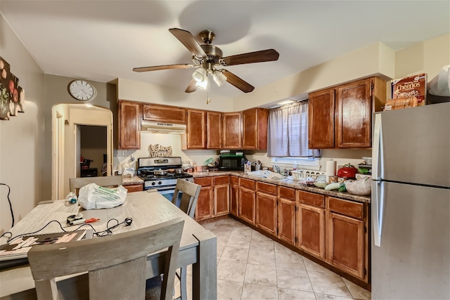 kitchen featuring light tile patterned floors, stainless steel appliances, sink, and ceiling fan