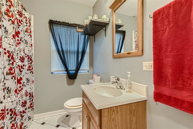 bathroom with vanity, toilet, and tile patterned floors