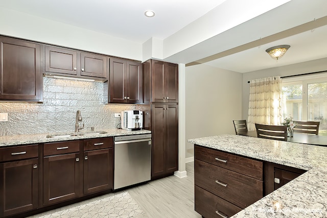 kitchen with dishwasher, sink, tasteful backsplash, and light stone countertops