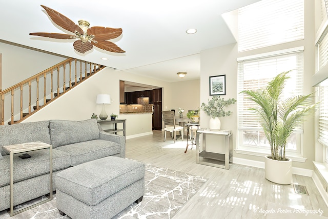 living room featuring light wood-type flooring and ceiling fan