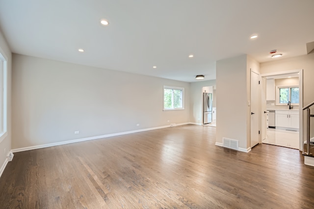 unfurnished living room featuring wood-type flooring and a wealth of natural light