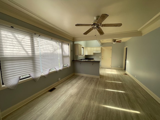 unfurnished living room with ceiling fan, ornamental molding, and light hardwood / wood-style flooring