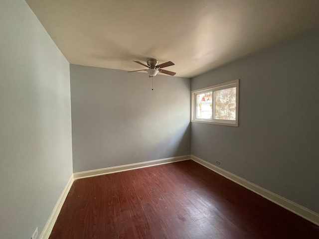 empty room with dark hardwood / wood-style floors and ceiling fan