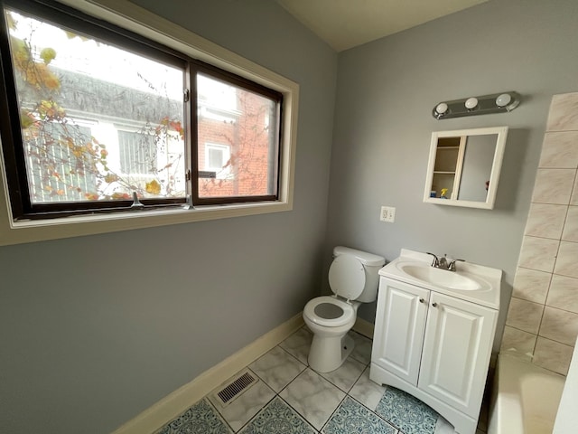 bathroom with tile patterned flooring, vanity, a bathtub, and toilet