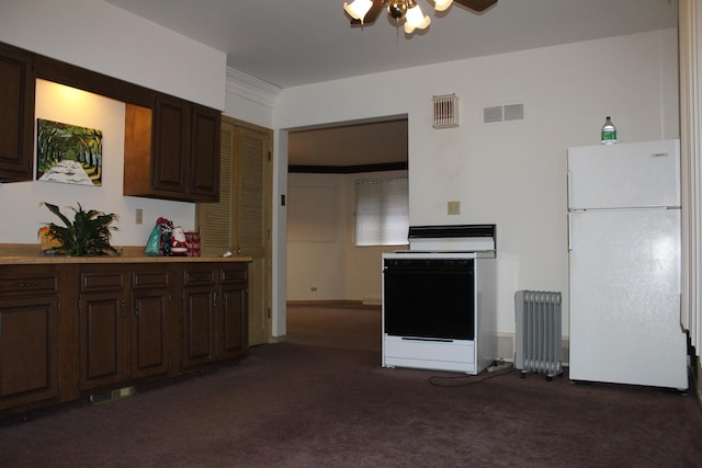 kitchen with radiator, dark carpet, white appliances, and ornamental molding