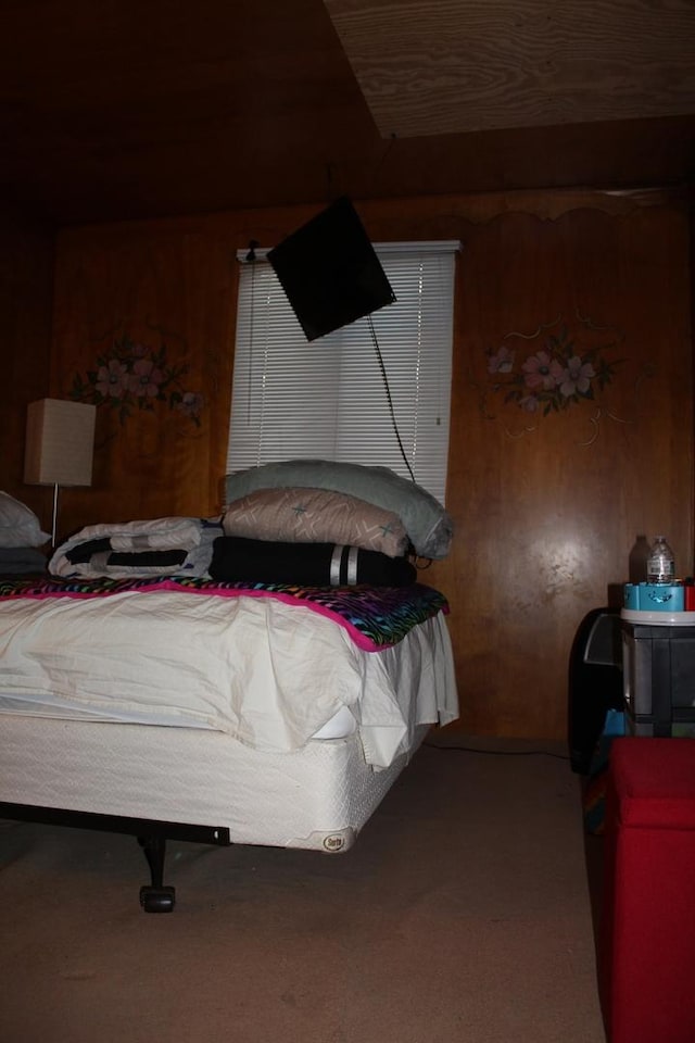 carpeted bedroom featuring wood walls