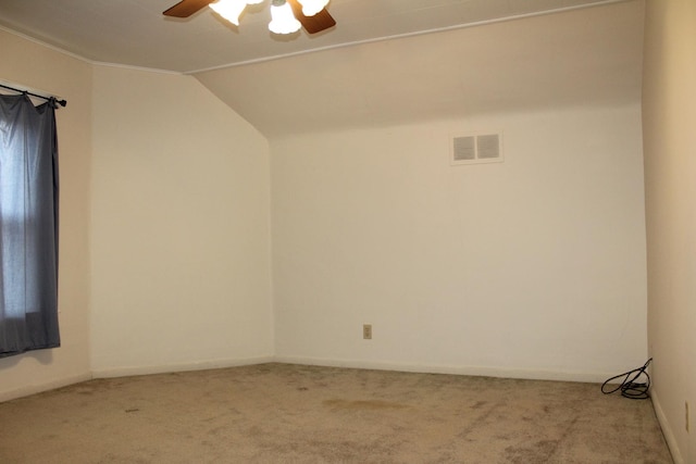 spare room with carpet, vaulted ceiling, and ceiling fan