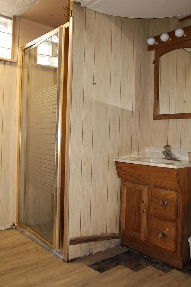 bathroom featuring hardwood / wood-style floors, vanity, and wooden walls