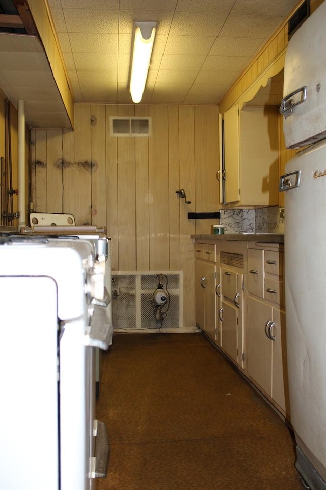 basement featuring dark colored carpet, washer / clothes dryer, and wood walls