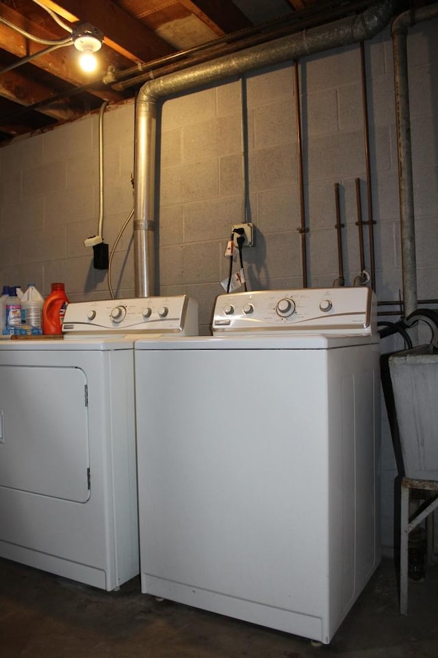 laundry area with separate washer and dryer and sink