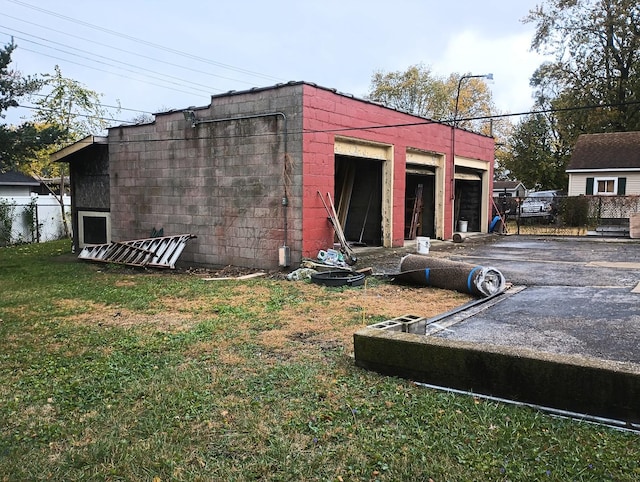 view of outbuilding featuring a lawn and a garage