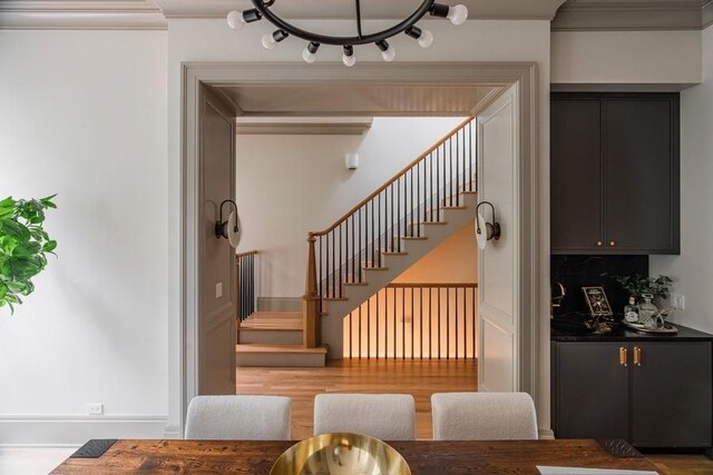 kitchen featuring tasteful backsplash, ventilation hood, stainless steel gas cooktop, light hardwood / wood-style floors, and hanging light fixtures