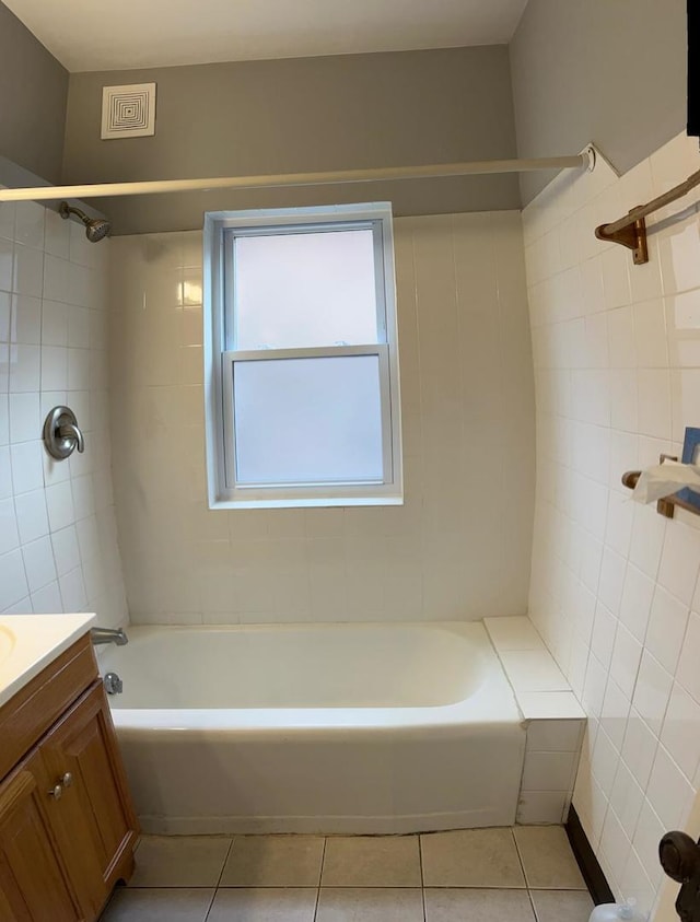 bathroom featuring tile walls, tiled shower / bath, tile patterned floors, and vanity