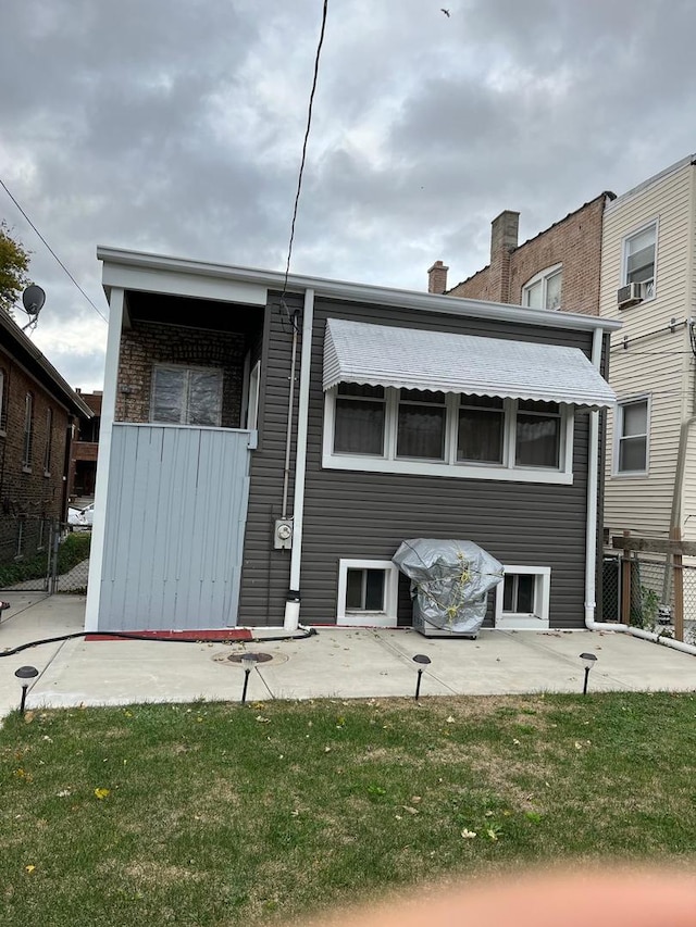 rear view of property with a patio area, a yard, and cooling unit