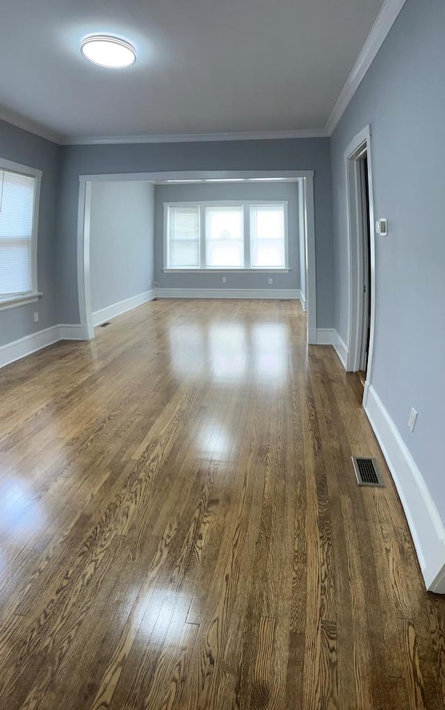 empty room with hardwood / wood-style flooring and crown molding