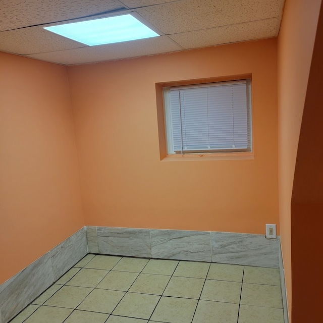 tiled empty room with a drop ceiling