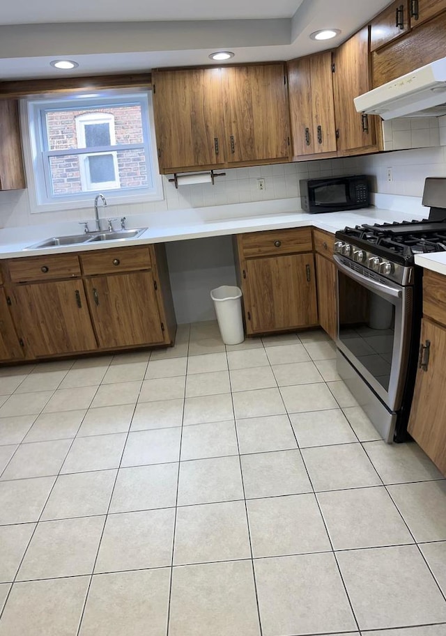 kitchen with sink, tasteful backsplash, stainless steel gas range, and light tile patterned floors