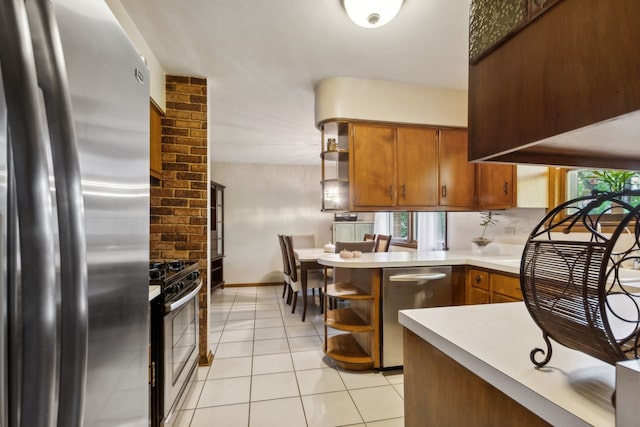 kitchen with kitchen peninsula, stainless steel appliances, and light tile patterned floors