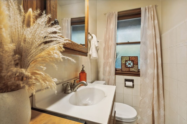 bathroom featuring vanity, toilet, tile walls, and hardwood / wood-style floors