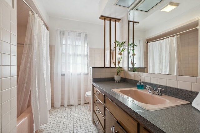 full bathroom featuring tasteful backsplash, shower / tub combo, toilet, tile walls, and vanity