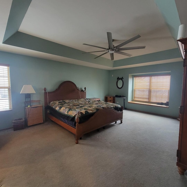 bedroom featuring a tray ceiling, ceiling fan, and carpet