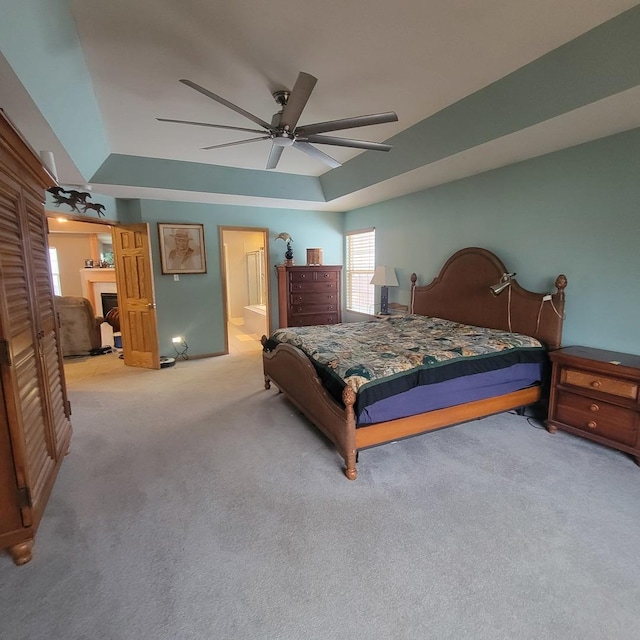 carpeted bedroom with ceiling fan, ensuite bathroom, and lofted ceiling