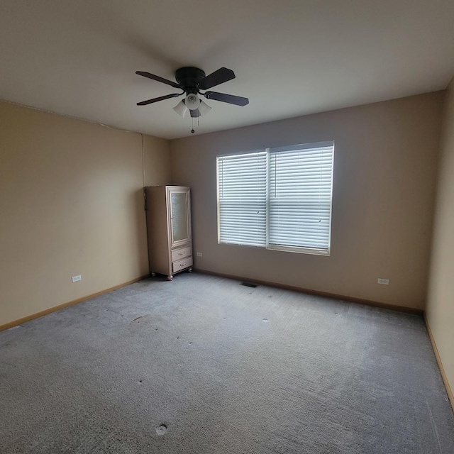 carpeted spare room with ceiling fan