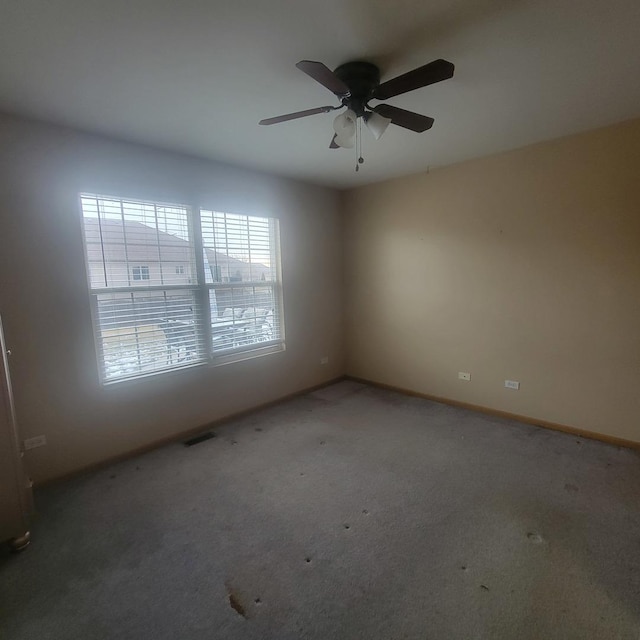 spare room with ceiling fan and carpet