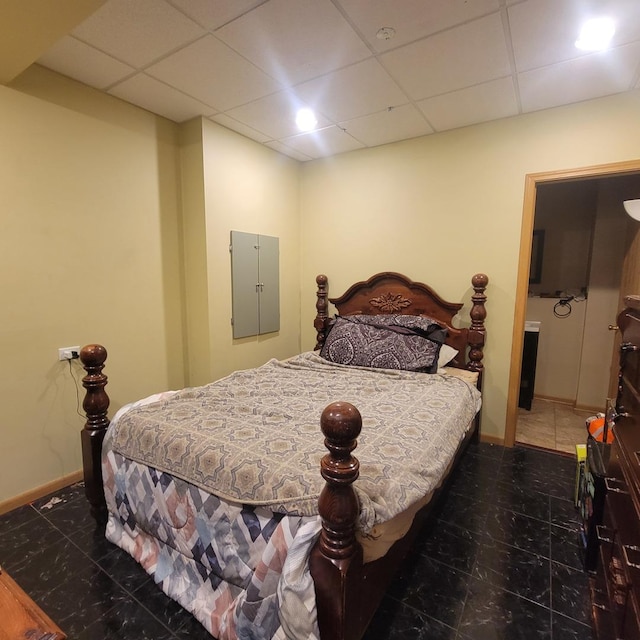 bedroom with a paneled ceiling and electric panel