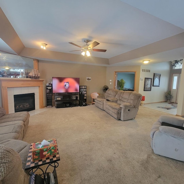 carpeted living room with ceiling fan and a fireplace