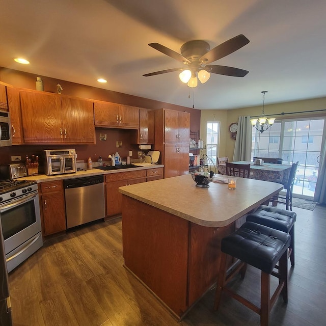 kitchen featuring pendant lighting, sink, dark hardwood / wood-style flooring, a center island, and stainless steel appliances