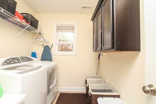 washroom featuring washer and dryer and cabinets