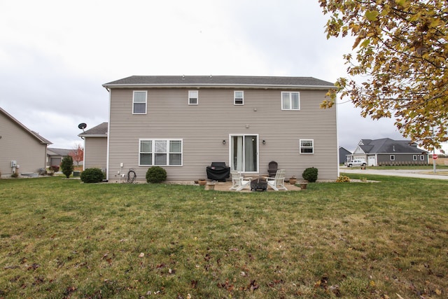 rear view of house with a patio and a lawn