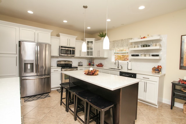 kitchen featuring appliances with stainless steel finishes, sink, a kitchen island, and white cabinets