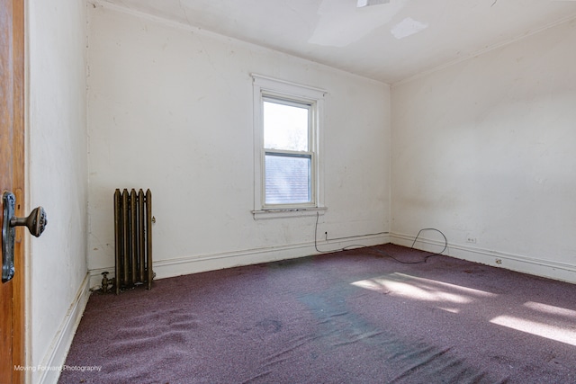 empty room with carpet flooring and radiator heating unit