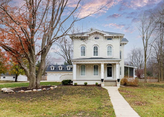 italianate-style house with a lawn, a sunroom, and a porch