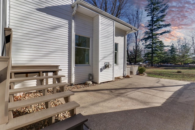 property exterior at dusk featuring a patio area