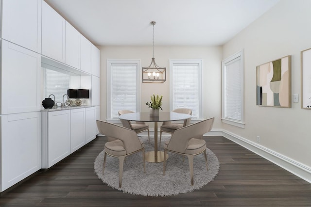 dining area featuring a notable chandelier and dark hardwood / wood-style flooring