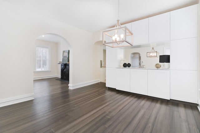 unfurnished dining area with a notable chandelier and dark hardwood / wood-style floors