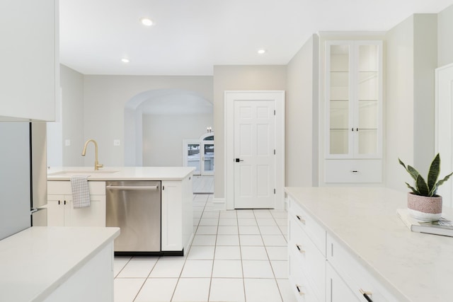 kitchen featuring stainless steel appliances, light tile patterned floors, white cabinets, and sink