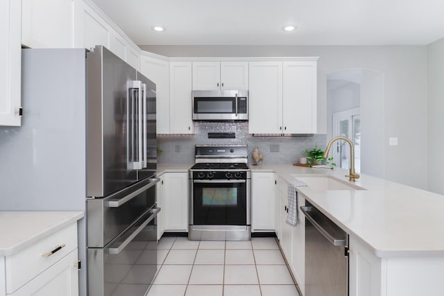 kitchen featuring sink, stainless steel appliances, white cabinets, and light tile patterned floors