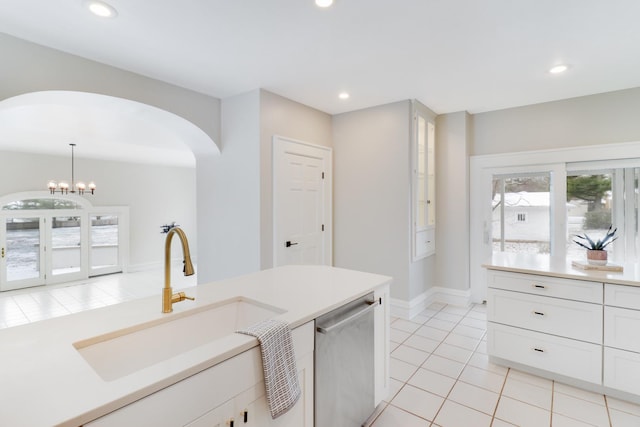 kitchen featuring dishwasher, hanging light fixtures, sink, white cabinetry, and light tile patterned flooring