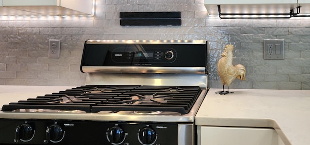 room details with backsplash and stainless steel range with gas stovetop