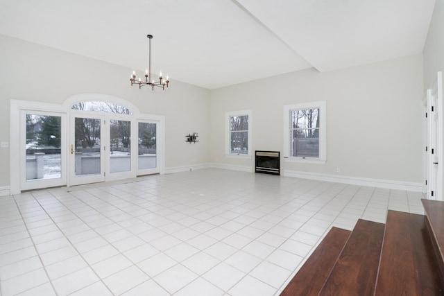 unfurnished living room with a wealth of natural light, a chandelier, and light tile patterned floors