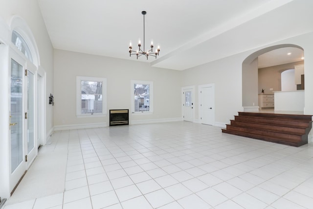 tiled spare room with an inviting chandelier