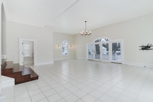 tiled empty room featuring an inviting chandelier and plenty of natural light