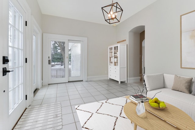 living room featuring light tile patterned flooring and an inviting chandelier